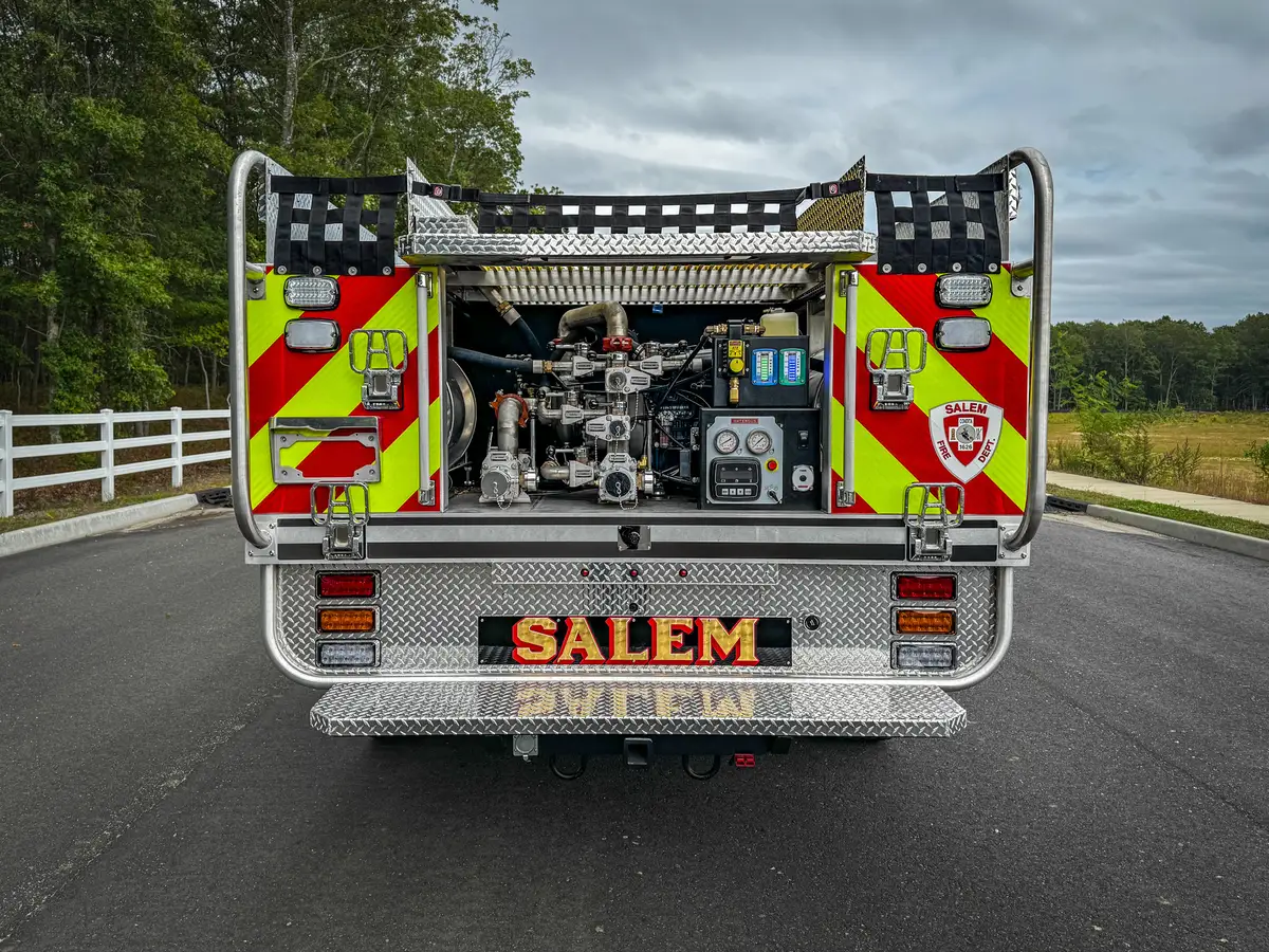 Straight rear exterior view showing chevron striping and rear-mounted pump compartment.